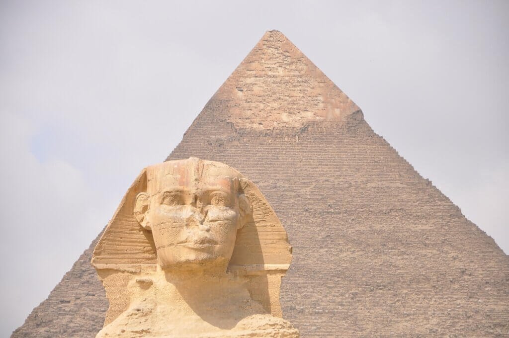 The Pyramids of Giza in Egypt, iconic historical landmarks, surrounded by golden desert sands under a clear sky.