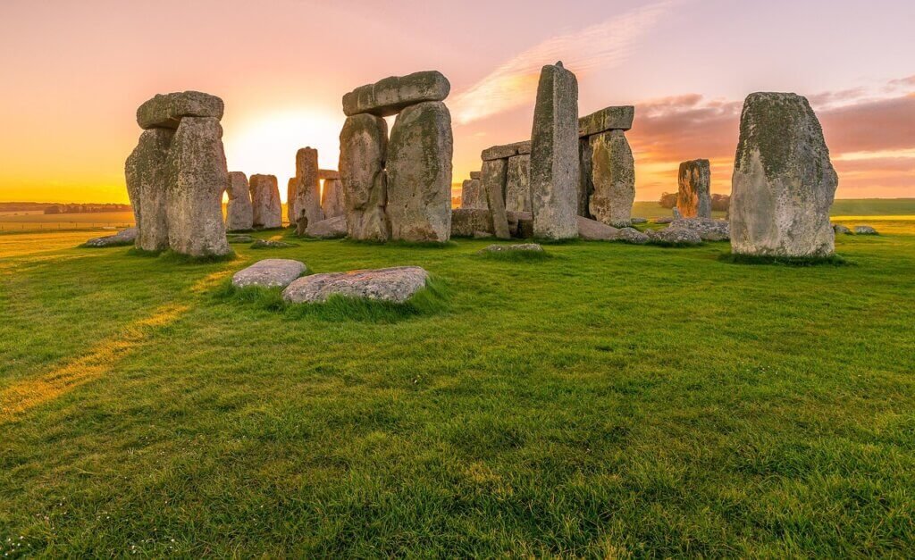 Stonehenge at sunrise in Wiltshire, England, an iconic historic monument glowing in the early morning light.