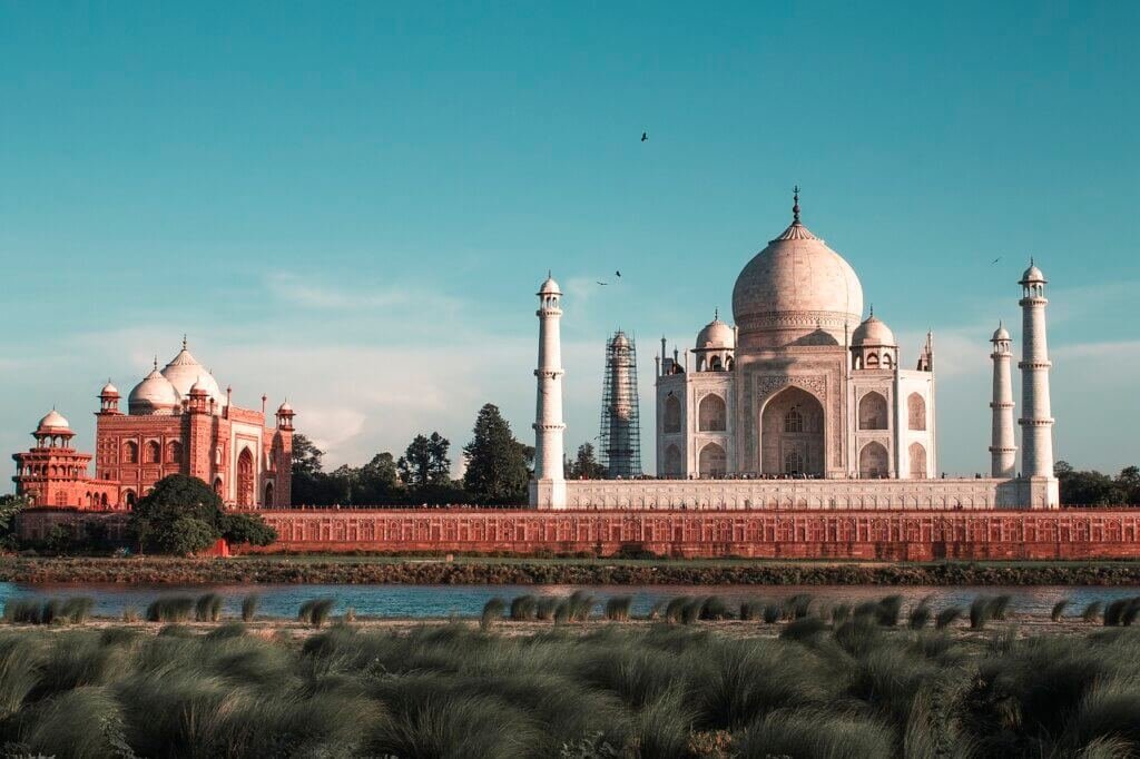 The Taj Mahal in Agra, India, a stunning white marble mausoleum surrounded by lush gardens and reflecting in the Yamuna River.