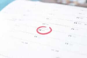 Calendar with a circled date showing the best time to book cheap flights for your next trip.