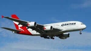 Qantas airplane in flight against a blue sky, symbolizing travel inspiration and adventure.